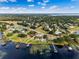 Expansive aerial view showcasing a lakeside home with private docks, lush landscaping, and a serene, tree-lined neighborhood at 10843 Lakeshore Dr, Clermont, FL 34711