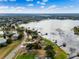 Breathtaking aerial view featuring a well-maintained home with lush landscaping and lake access at 10843 Lakeshore Dr, Clermont, FL 34711