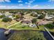 Lakeside home featuring a private dock, backyard pool, lush green lawn, mature trees, and solar panels at 10843 Lakeshore Dr, Clermont, FL 34711