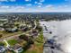Picturesque aerial view of the home set on a lakefront lot with dock, surrounded by verdant landscaping at 10843 Lakeshore Dr, Clermont, FL 34711