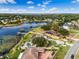Waterfront house with a private dock, and lush green lawn, mature trees, and backyard pool at 10843 Lakeshore Dr, Clermont, FL 34711