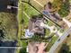 Aerial view of an expansive estate with a pool, well-manicured lawn, and lake access at 10843 Lakeshore Dr, Clermont, FL 34711