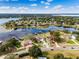 Stunning aerial view of a waterfront property with lush landscaping and private dock on a serene lake at 10843 Lakeshore Dr, Clermont, FL 34711