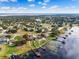 Aerial shot of the lakefront home with lush landscaping, private pool, and dock on a lily-covered lake at 10843 Lakeshore Dr, Clermont, FL 34711