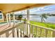 Covered balcony with pillars overlooking a pool, landscaped backyard, and the lake at 10843 Lakeshore Dr, Clermont, FL 34711
