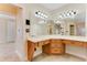 Bright bathroom with a wooden vanity, large mirrors, and decorative lighting fixtures at 10843 Lakeshore Dr, Clermont, FL 34711