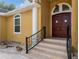Elegant home entrance with a beautifully stained double front door, stone steps, and classic architectural details at 10843 Lakeshore Dr, Clermont, FL 34711