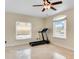 Sunlit exercise room with tile flooring and a treadmill at 10843 Lakeshore Dr, Clermont, FL 34711
