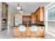 Open kitchen with granite counters, wood cabinets, and a stone fireplace at 10843 Lakeshore Dr, Clermont, FL 34711