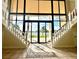 Open living room with tile flooring, large windows, and staircase at 10843 Lakeshore Dr, Clermont, FL 34711