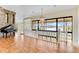Spacious living room with hardwood floors, grand piano, and large windows overlooking scenic waterfront views at 10843 Lakeshore Dr, Clermont, FL 34711