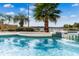 Beautiful waterfront pool featuring swim-up bar seating, waterfall, and lush palm trees under a sunny sky at 10843 Lakeshore Dr, Clermont, FL 34711
