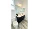 Bathroom featuring dark cabinets, modern toilet, and wood look flooring at 224 Trinity Ridge Cir, Davenport, FL 33897