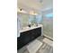 Bathroom featuring double vanity, dark cabinets and glass shower at 224 Trinity Ridge Cir, Davenport, FL 33897