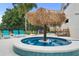 Backyard with a covered lounge area with a spa and lounge chairs by the pool at 7487 Gathering Dr, Reunion, FL 34747