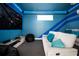 Comfortable theater room with a large screen, sofa, and blue LED accent lighting at 7487 Gathering Dr, Reunion, FL 34747