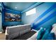 Cozy theater room with a large screen, sofa, and decorative blue wall stripes at 7487 Gathering Dr, Reunion, FL 34747