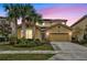 Two-story house with tan exterior, palm trees, and a two-car garage at 6078 Broad Oak Dr, Davenport, FL 33837