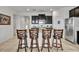 Island kitchen with dark wood cabinets, granite countertops and four barstools at 6078 Broad Oak Dr, Davenport, FL 33837