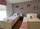 bedroom featuring two twin beds, striped accent wall, and bright natural light at 8953 California Palm Rd, Kissimmee, FL 34747