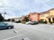 Exterior view of colorful townhomes with assigned parking and landscaping at 8953 California Palm Rd, Kissimmee, FL 34747