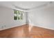 A bedroom with white walls and unique hardwood herringbone pattern flooring, and a window overlooking greenery at 1110 W Ivanhoe Blvd # 6, Orlando, FL 32804