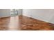 An empty bedroom with light-colored walls and light-colored hardwood floors and a glass door to the balcony at 1110 W Ivanhoe Blvd # 6, Orlando, FL 32804