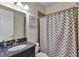 Bathroom with a blue granite countertop vanity, a walk-in shower, and gray chevron shower curtain at 9149 Outlook Rock Trl, Windermere, FL 34786