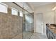 Bright bathroom features a luxurious shower with a glass surround and a dark wood vanity with stone countertop at 9149 Outlook Rock Trl, Windermere, FL 34786