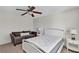 Bright bedroom with a white bed frame, couch, ceiling fan, and bedside table with lamps at 9149 Outlook Rock Trl, Windermere, FL 34786