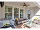 Covered patio with a grill, seating area, ceiling fan, and door with blinds at 9149 Outlook Rock Trl, Windermere, FL 34786