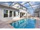 Screened-in pool area with a pool, spa, patio furniture, and view of the house at 9149 Outlook Rock Trl, Windermere, FL 34786