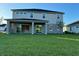 The backyard features a covered patio, a green lawn, and sliding glass doors at 3219 Legends Preserve Dr, Daytona Beach, FL 32124