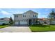 Charming two-story home with a manicured lawn and a paved driveway leading to a two-car garage at 3219 Legends Preserve Dr, Daytona Beach, FL 32124