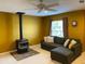Living room featuring a modern couch, neutral carpet, and a unique fireplace at 466 Pepin Dr, Orlando, FL 32825