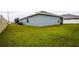 Side yard view showing grassy lawn and home exterior at 1080 Condor Dr, Haines City, FL 33844