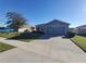 Single-story home with gray exterior, two-car garage, and landscaped yard at 1080 Condor Dr, Haines City, FL 33844
