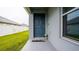Front door entrance with welcome mat and landscaping at 1080 Condor Dr, Haines City, FL 33844