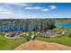 Aerial view of a community park featuring walking trails, mature trees, and a playground with lake views at 14038 Scarlet Aster Aly, Winter Garden, FL 34787