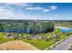 Aerial view of a community park featuring walking trails, mature trees, and a playground with lake views at 14038 Scarlet Aster Aly, Winter Garden, FL 34787