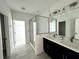 Sleek bathroom with double vanity, glass-enclosed shower, modern fixtures, and ceramic tile flooring at 14038 Scarlet Aster Aly, Winter Garden, FL 34787