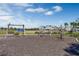 Swings and climbing structures in a playground with mature landscaping and community homes in the background at 14038 Scarlet Aster Aly, Winter Garden, FL 34787