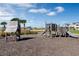 A playground area features wooden structures, a slide, and a mulch ground covering surrounded by landscaping and trees at 14038 Scarlet Aster Aly, Winter Garden, FL 34787