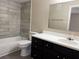 Bathroom featuring wood-look accent wall and dark vanity at 5635 Devonbriar Way # 103, Orlando, FL 32822
