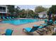 Community pool featuring inviting turquoise lounge chairs and tables, perfect for relaxation and enjoying sunny days at 13103 Mulberry Park Dr # 824, Orlando, FL 32821