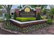 Landscaped entrance sign for Plantation Park Luxury Condominiums with vibrant flower beds and manicured greenery at 13103 Mulberry Park Dr # 824, Orlando, FL 32821
