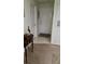 Hallway with carpet leading to a white front door, and a small decorative table in the entryway at 13103 Mulberry Park Dr # 824, Orlando, FL 32821