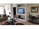 Cozy living room featuring built-in shelves with a TV, a glass coffee table, and neutral carpet at 13103 Mulberry Park Dr # 824, Orlando, FL 32821