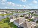 Aerial view showing community homes and a lake surrounding a community of similar properties and well-manicured landscaping at 4949 Olivia Ct, St Cloud, FL 34772