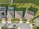 Aerial view of homes with brick driveways, manicured lawns, and a community lake with a private dock at 4949 Olivia Ct, St Cloud, FL 34772